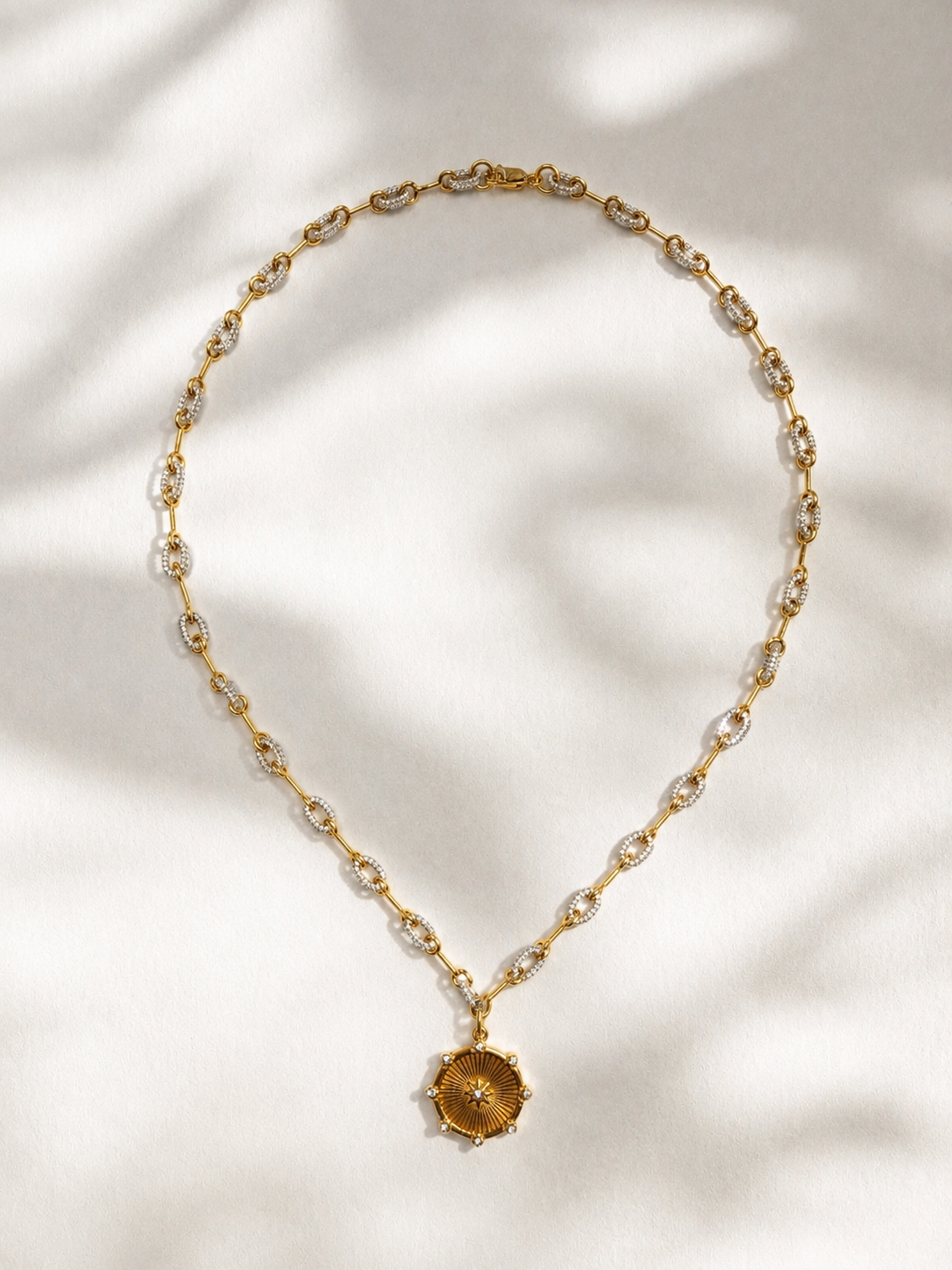 Gold necklace with a pendant on a light background
